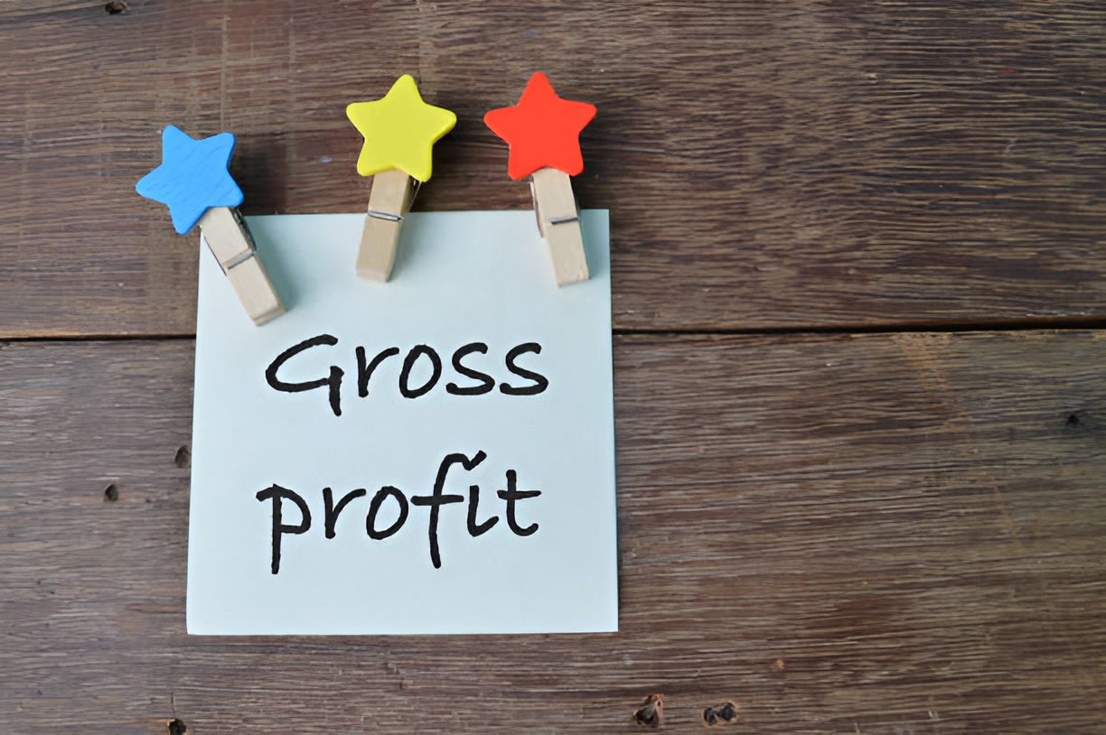 sticky note labeled 'gross profit' and wooden star paper clips